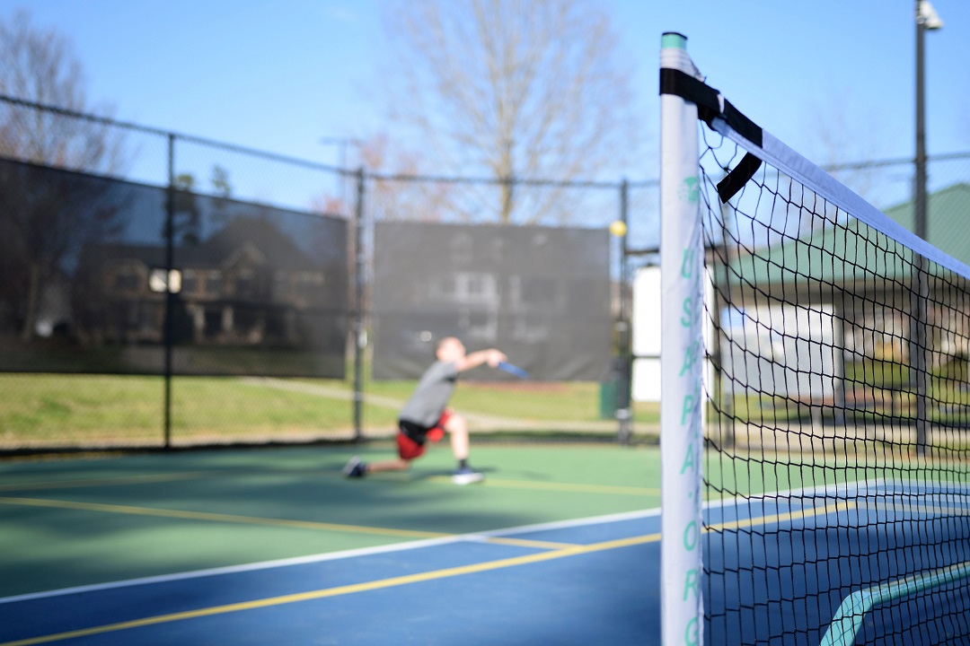 Pickleball player behind close-up of net