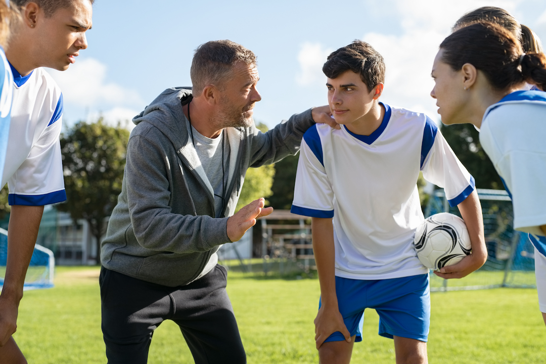 Soccer coach consulting with players