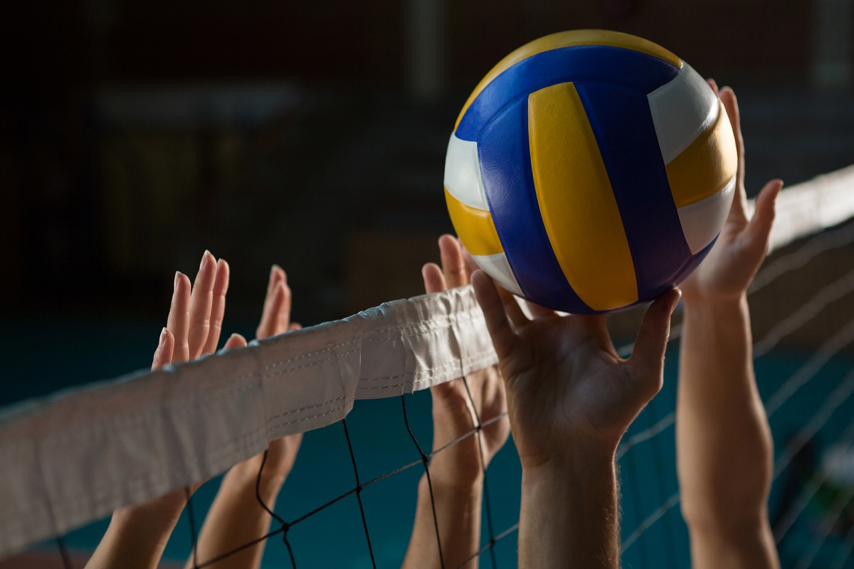 Hands reaching for a volleyball