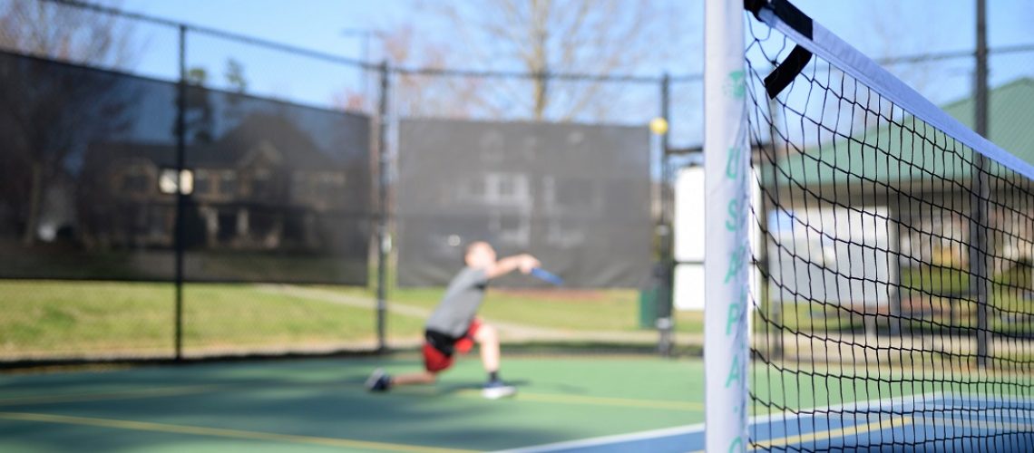 Pickleball player behind close-up of net