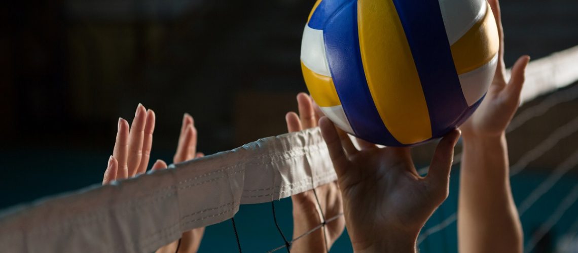 Hands reaching for a volleyball