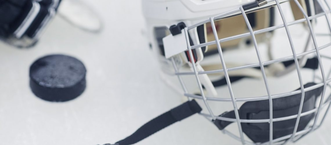 Background image of hockey equipment lying on ice in outdoor skating arena, closeup