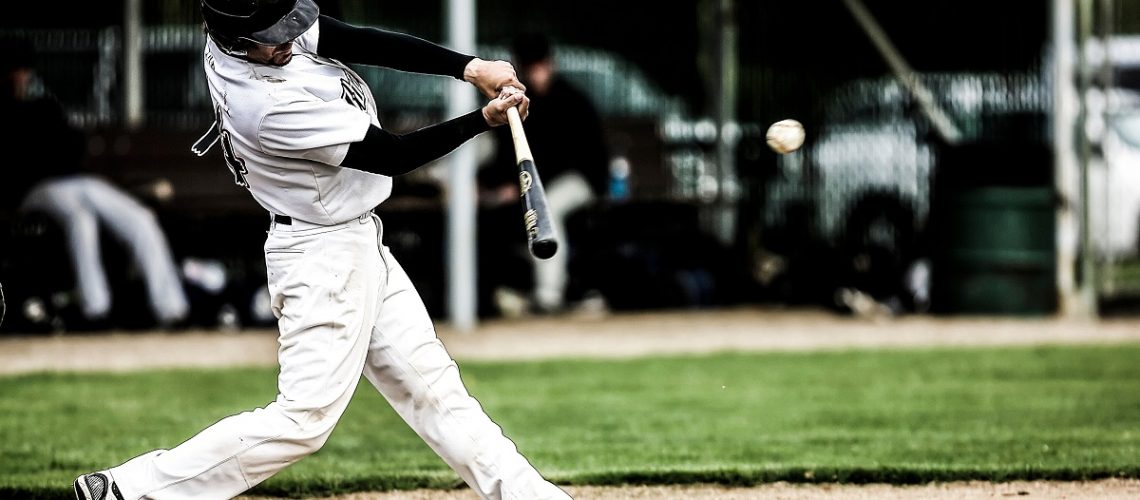 Baseball player swinging his bat at an incoming pitch