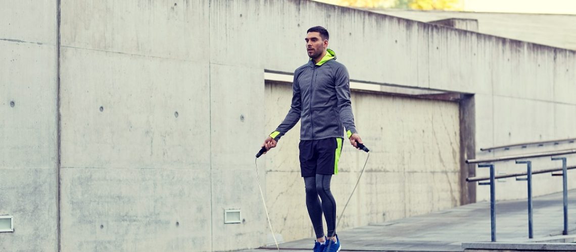 Man exercising with jump-rope outdoors