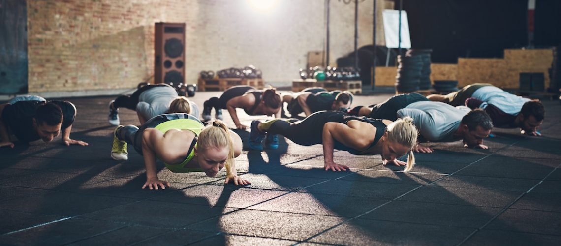 A group of people in athletic gear doing push-ups