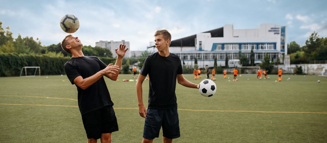 Soccer players training with balls on the field