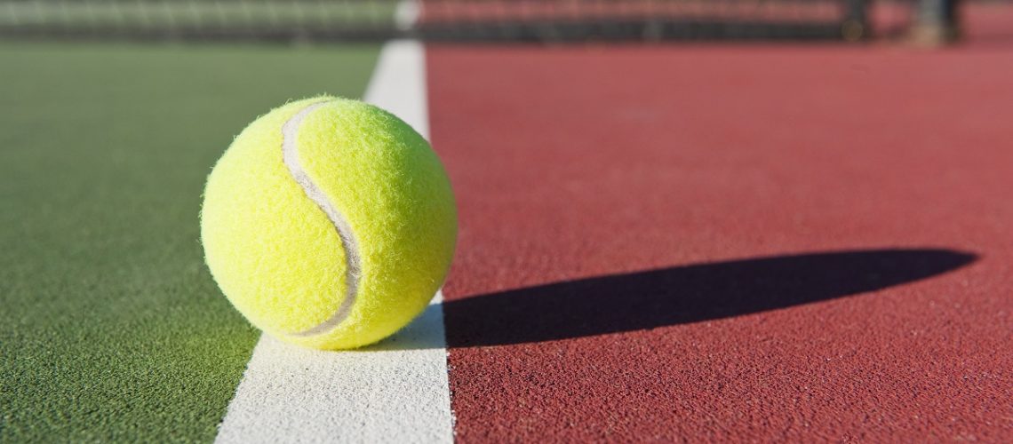 Tennis ball resting on the line