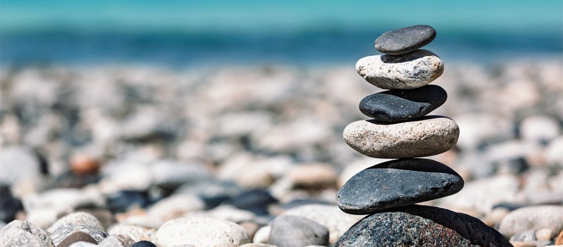 Zen meditation background -  balanced stones stack close up on sea beach