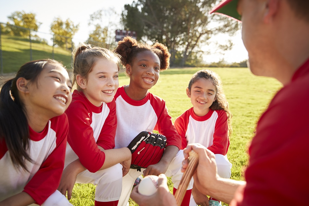 Baseball team in a team huddle with coach, listening