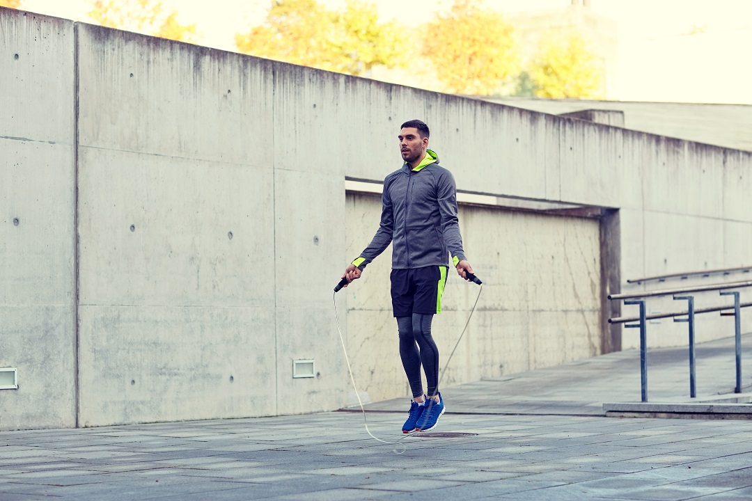 Man exercising with jump-rope outdoors