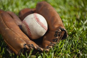 Vintage baseball mitt with an old ball in the grass