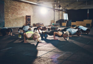 A group of people in athletic gear doing push-ups