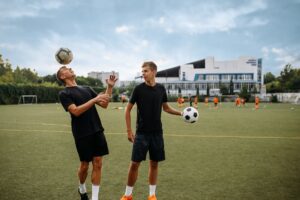 Soccer players training with balls on the field